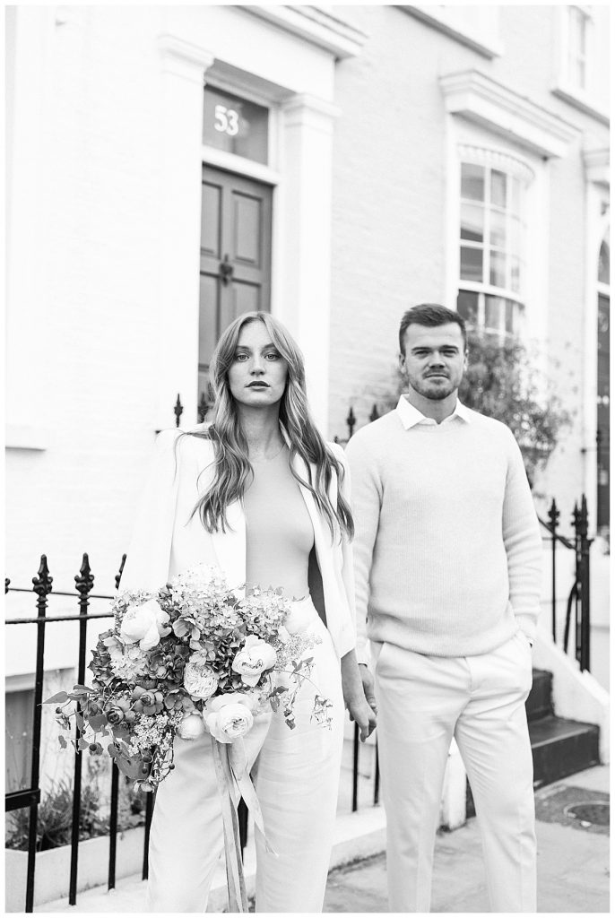 Couple with bouquet on sidewalk